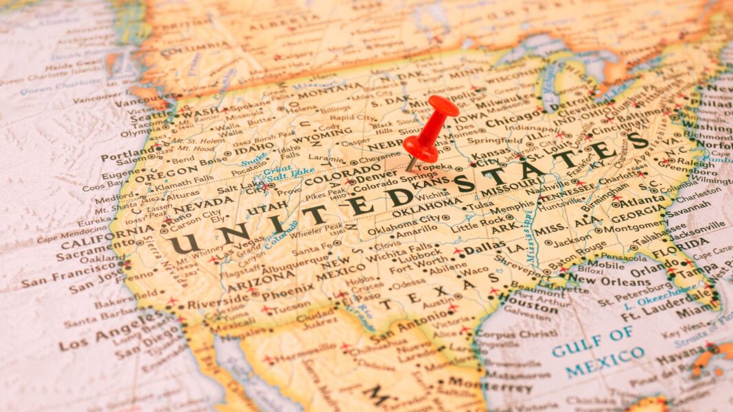 Ilustración editorial de una periodista analizando datos económicos de Estados Unidos y México, con gráficos, industria y símbolos de comercio exterior de fondo.