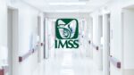 Logotipo del IMSS en el interior de un pasillo de una unidad médica con tránsito de pacientes y personal de salud en Chihuahua